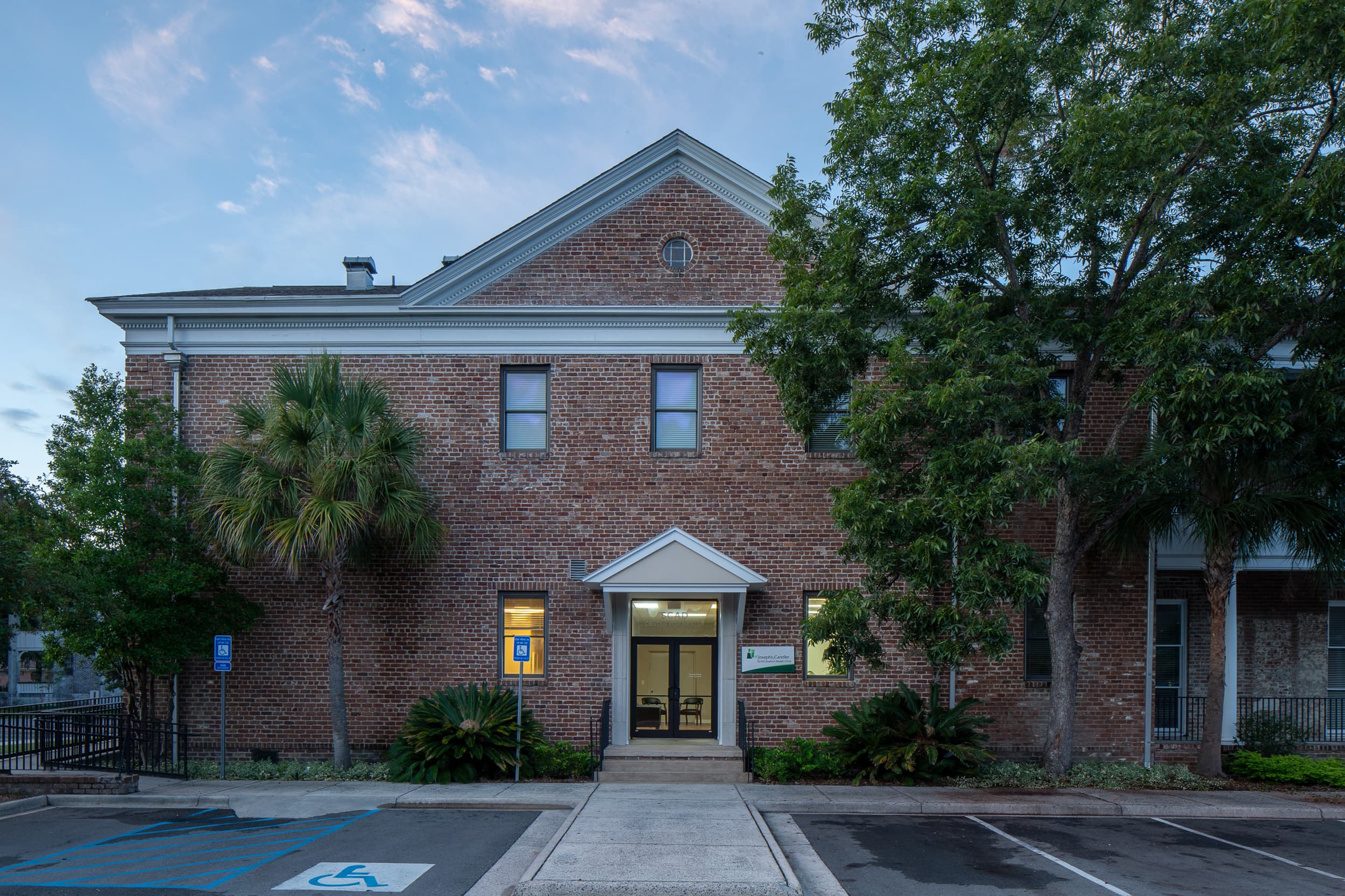Historic SCAD brick building with central entrance, trees, and landscaping — before retouching