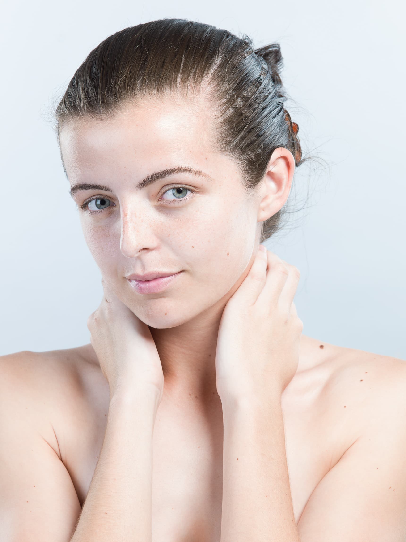 Beauty portrait of a woman against a bright white background — before retouching